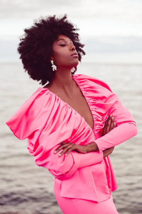 Full-length coral suit frame by the water